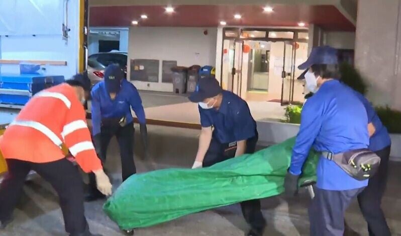 仵工於凌晨1時許將遺體舁送殮房。(有線新聞截圖)
