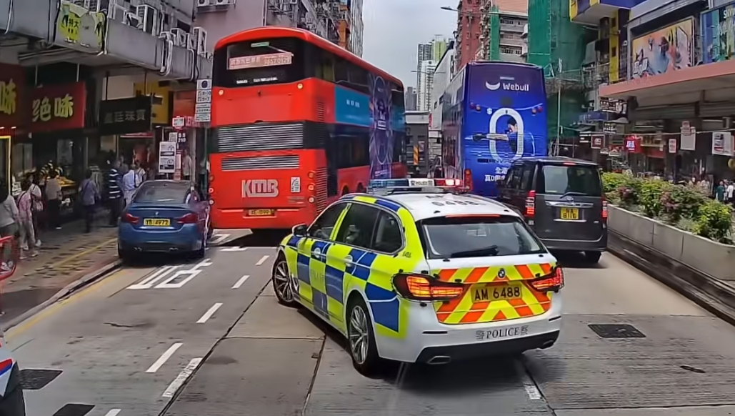 深水埗一輛寶馬私家車為逃避警車追截,在馬路左穿右插剷巴士站攝車罅,更衝紅燈橫過行人過路處,險撞途人。(車cam L(香港群組)fb)