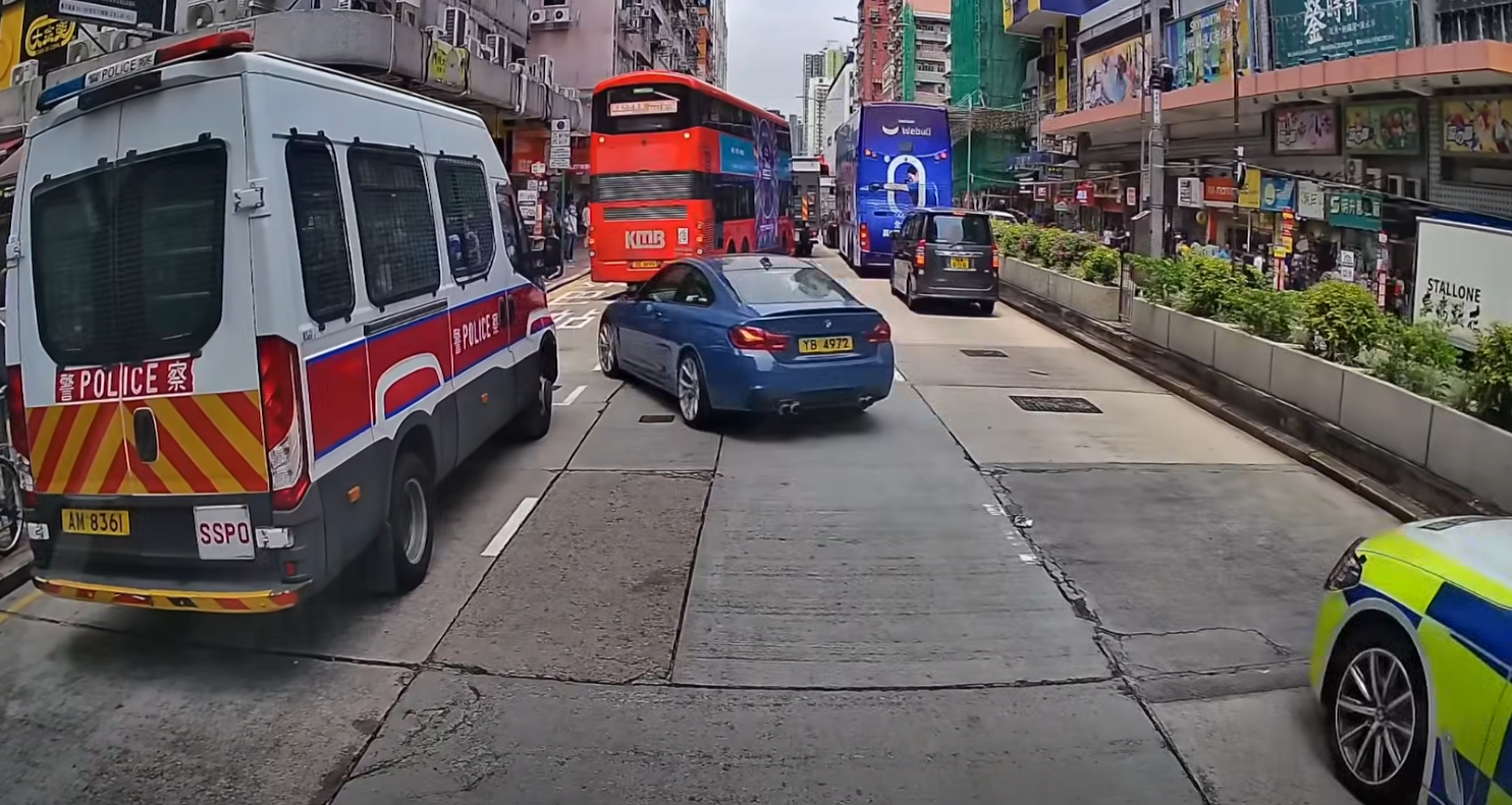 深水埗一輛寶馬私家車為逃避警車追截,在馬路左穿右插剷巴士站攝車罅,更衝紅燈橫過行人過路處,險撞途人。(車cam L(香港群組)fb)