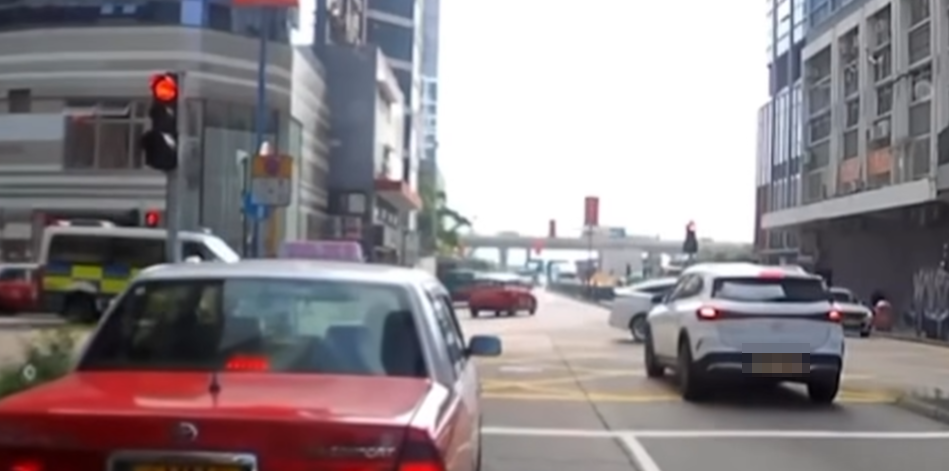 觀塘一輛私家車涉衝紅燈後,被橫向駛出車輛阻擋停在「黃格仔」;一輛亮起警燈的警車與交通警電單車從橫街駛至「斷正」目擊事件。(車cam L(香港群組)fb)