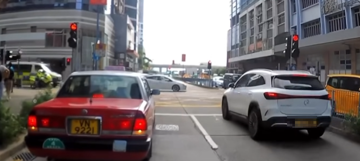 觀塘一輛私家車涉衝紅燈後,被橫向駛出車輛阻擋停在「黃格仔」;一輛亮起警燈的警車與交通警電單車從橫街駛至「斷正」目擊事件。(車cam L(香港群組)fb)