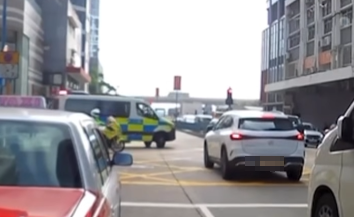 觀塘一輛私家車涉衝紅燈後,被橫向駛出車輛阻擋停在「黃格仔」;一輛亮起警燈的警車與交通警電單車從橫街駛至「斷正」目擊事件。(車cam L(香港群組)fb)