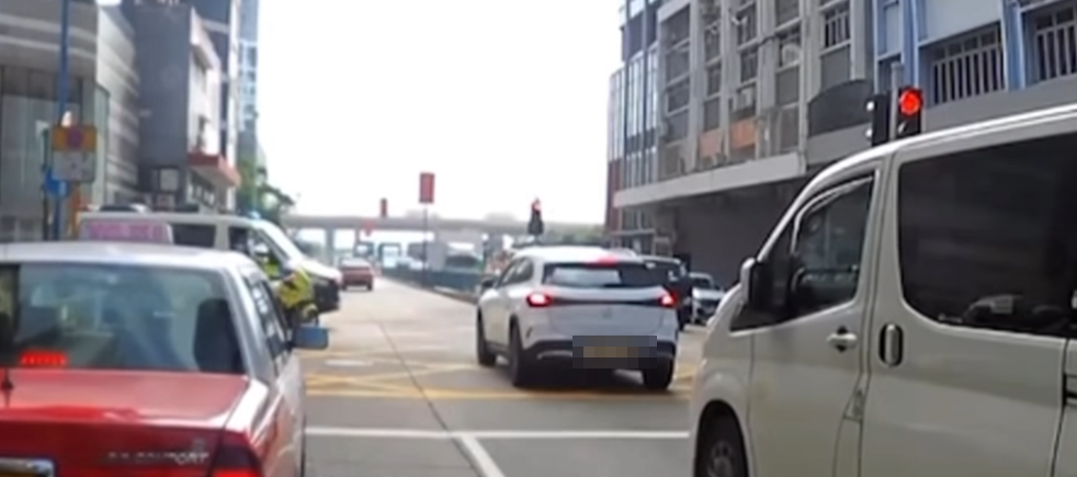 觀塘一輛私家車涉衝紅燈後,被橫向駛出車輛阻擋停在「黃格仔」;一輛亮起警燈的警車與交通警電單車從橫街駛至「斷正」目擊事件。(車cam L(香港群組)fb)