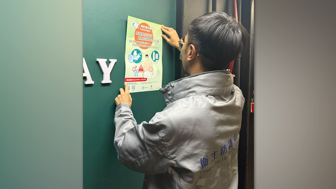 近期猴痘個案大幅上升，衞生防護中心人員到訪娛樂場所張貼宣傳海報。（政府新聞處）