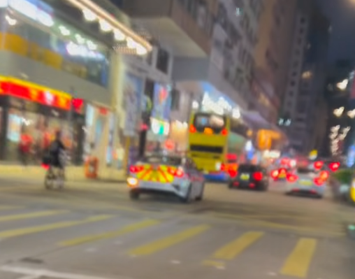 油麻地一名疑是外賣員的非華裔男子駕駛電動單車沿快線行駛,中線有一輛警車,慢線亦有另一名疑是外賣員的男子駕駛電動單車。(「車cam L(香港群組)」fb)