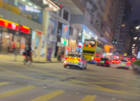 油麻地一名疑是外賣員的非華裔男子駕駛電動單車沿快線行駛,中線有一輛警車,慢線亦有另一名疑是外賣員的男子駕駛電動單車。(「車cam L(香港群組)」fb)
