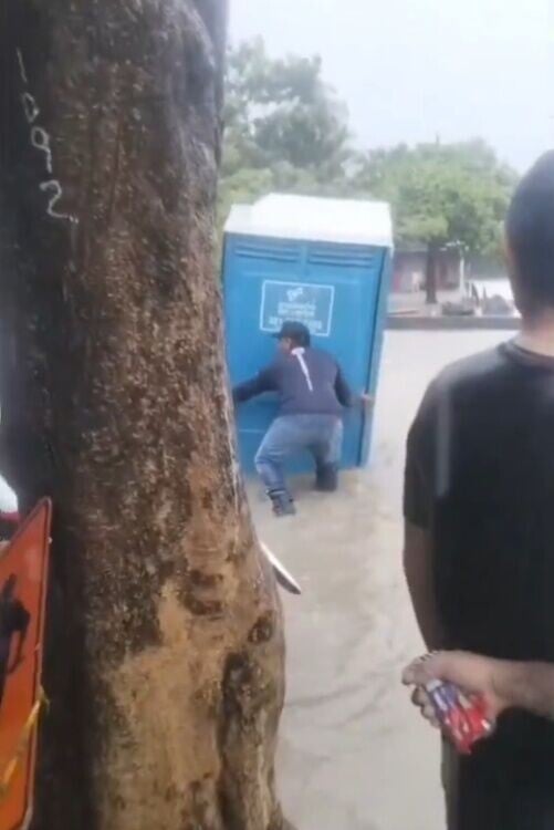 所幸流水稍緩下來,一名男路人趁機涉水將廁所移到路邊。(X)
