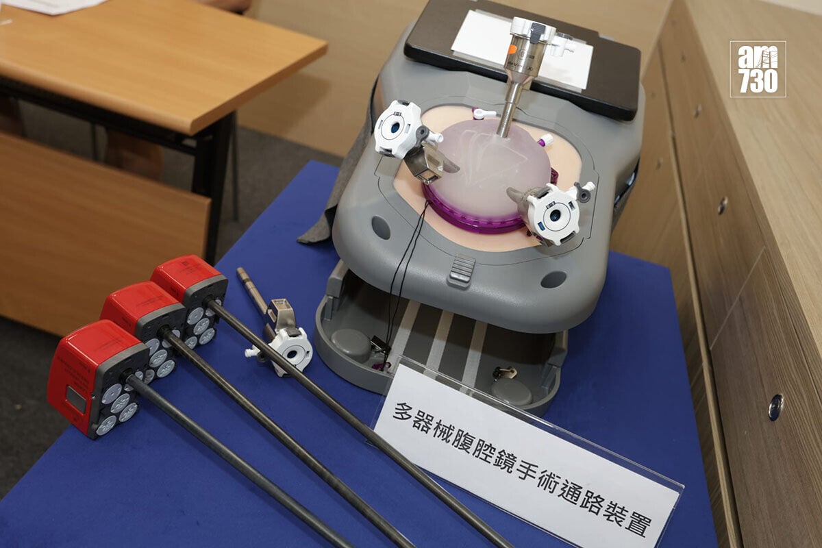 瑪麗醫院利用「多器械腹腔鏡手術通路裝置」(紫色設備),進行全港首次單切口機械臂手術。(鍾式明攝)