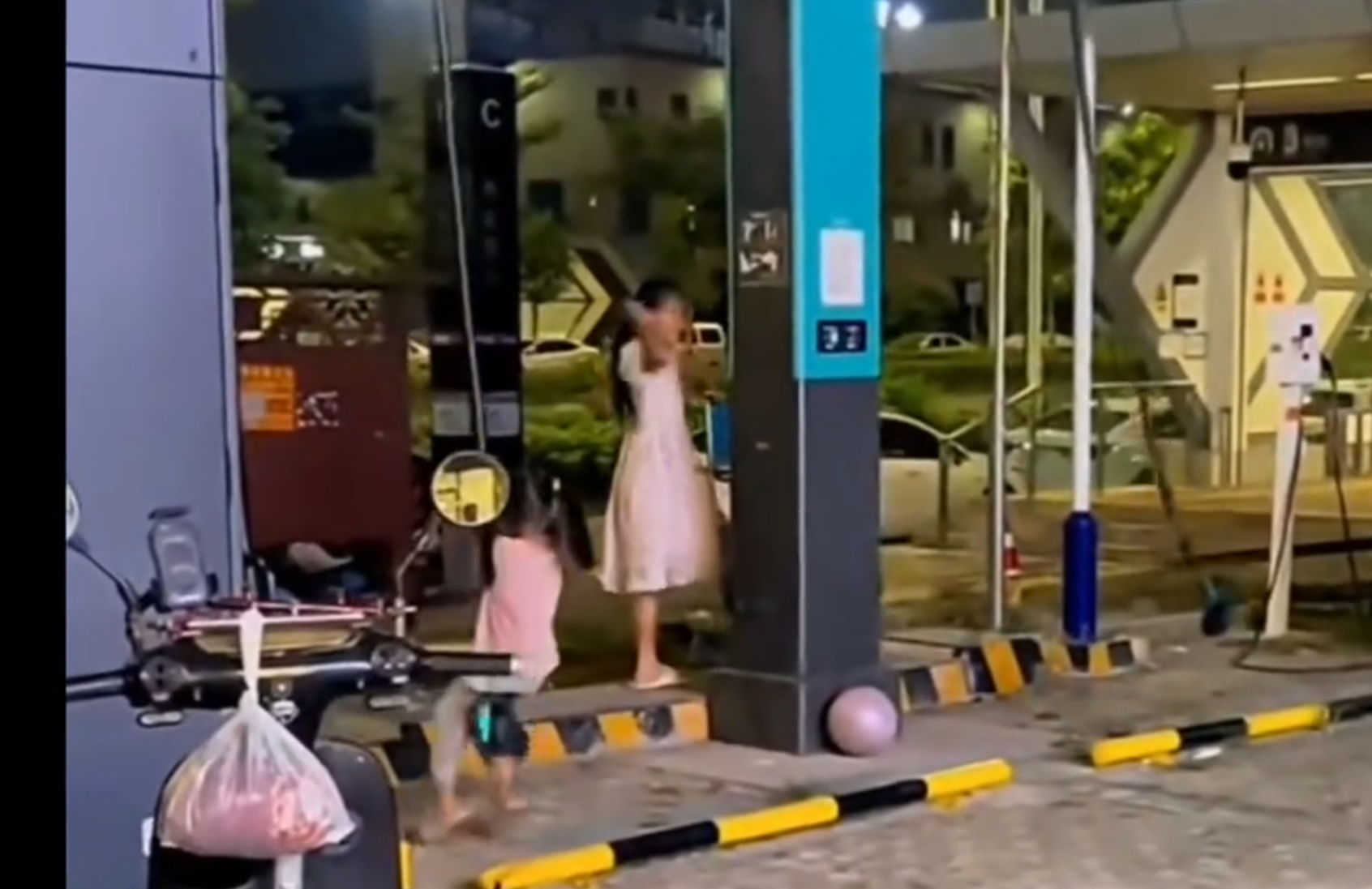 多名女童在廣西南寧一個汽車充電站,把高壓充電槍的電纜當鞦韆擺盪。(影片截圖)