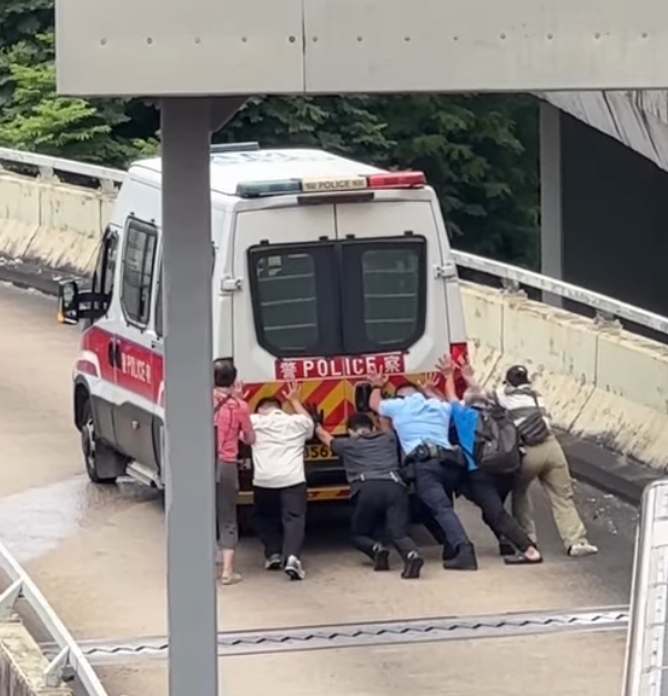 九龍灣一輛警車途經一段上斜天橋路段時突然「死火」,後方巴士受阻未能前行形成車龍。巴士司機及熱心乘客見狀,下車主動上前協助警員推車。(Threads)