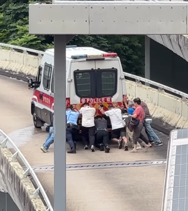 九龍灣一輛警車途經一段上斜天橋路段時突然「死火」,後方巴士受阻未能前行形成車龍。巴士司機及熱心乘客見狀,下車主動上前協助警員推車。(Threads)