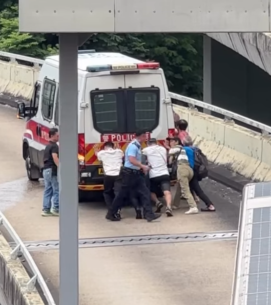 九龍灣一輛警車途經一段上斜天橋路段時突然「死火」,後方巴士受阻未能前行形成車龍。巴士司機及熱心乘客見狀,下車主動上前協助警員推車。(Threads)