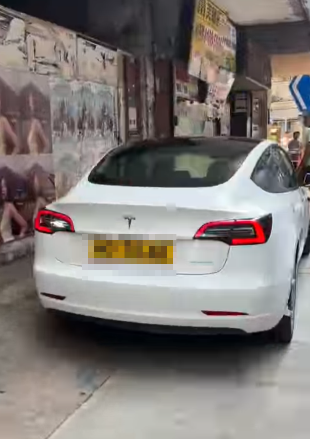 一輛Tesla電動車沿灣仔菲林明道30號外的行人路上倒車(Threads)