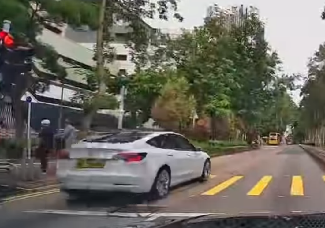 一輛Tesla電動車沿灣仔菲林明道30號外的行人路上倒車,同一車牌私家車曾於8月31日早上7時在將軍澳醫院外寶寧路過路處衝燈,未知司機是否為同一人。(Threads)