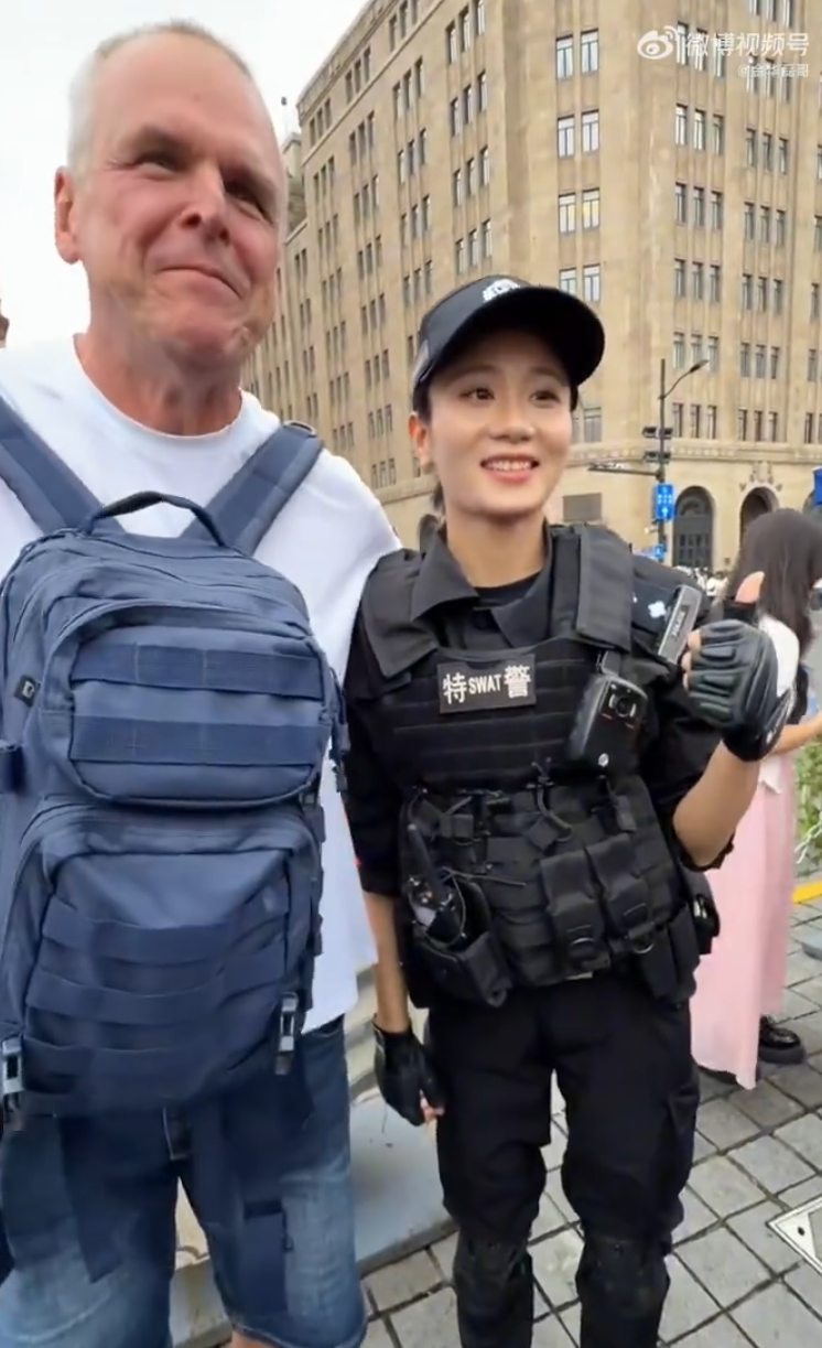 上海外灘外籍遊客向女特警錢雪穎提出合照請求時,伸手欲摟抱肩膀。她提醒「Don’t touch me」令該名遊客縮手。(影片截圖)