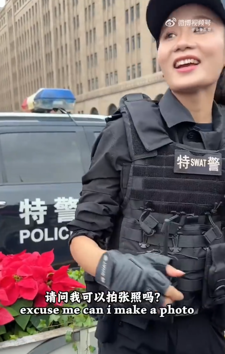 上海外灘外籍遊客向女特警錢雪穎提出合照請求時,伸手欲摟抱肩膀。她提醒「Don’t touch me」令該名遊客縮手。(影片截圖)
