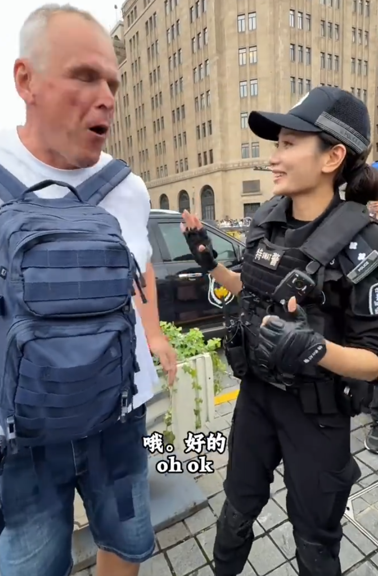 上海外灘外籍遊客向女特警錢雪穎提出合照請求時,伸手欲摟抱肩膀。她提醒「Don’t touch me」令該名遊客縮手。(影片截圖)