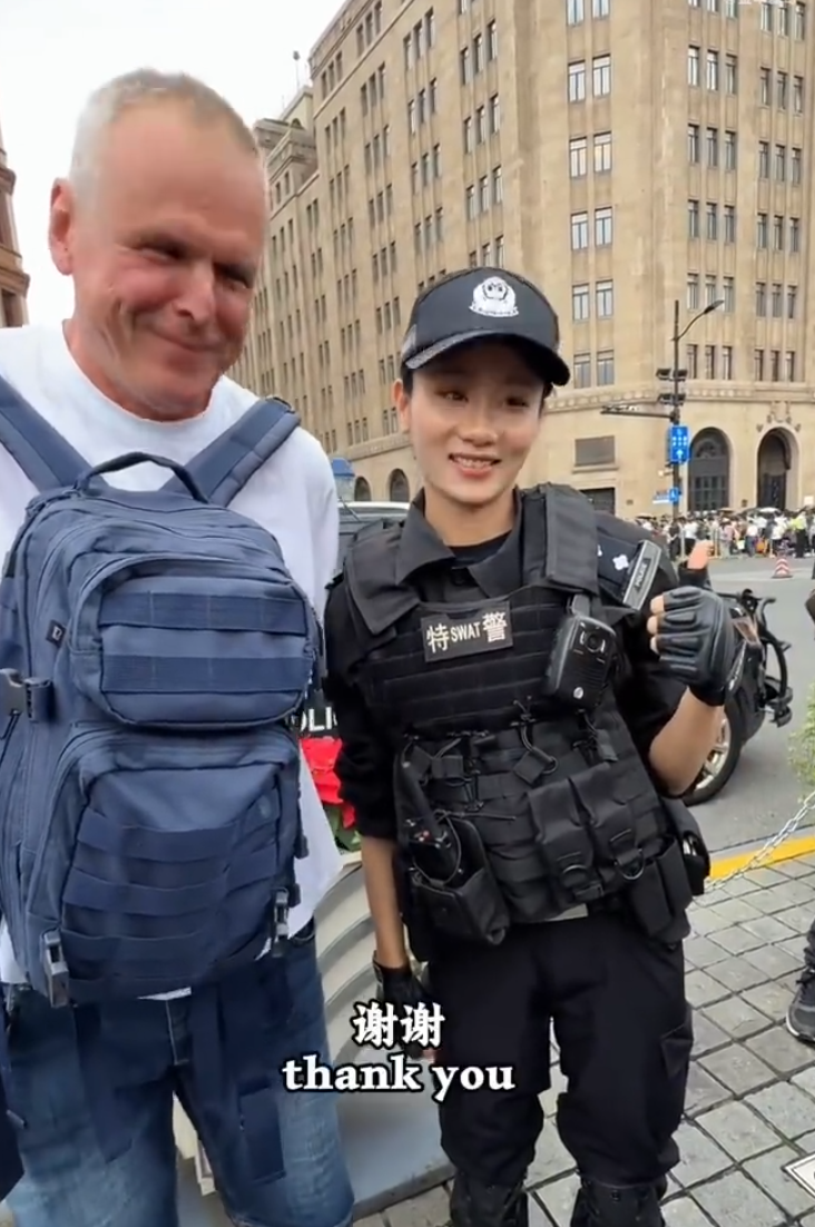 上海外灘外籍遊客向女特警錢雪穎提出合照請求時,伸手欲摟抱肩膀。她提醒「Don’t touch me」令該名遊客縮手。(影片截圖)