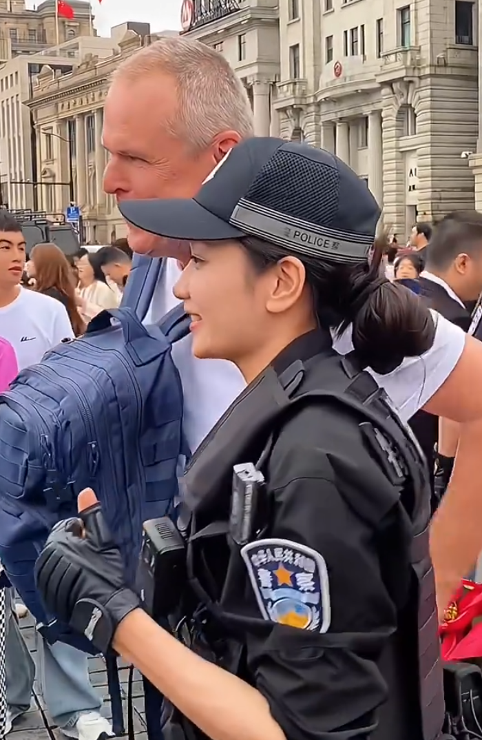 上海外灘外籍遊客向女特警錢雪穎提出合照請求時,伸手欲摟抱肩膀。她提醒「Don’t touch me」令該名遊客縮手。(影片截圖)