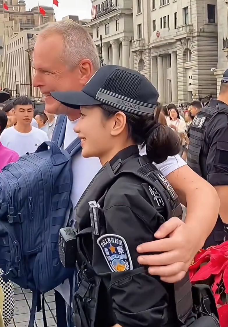 上海外灘外籍遊客向女特警錢雪穎提出合照請求時,伸手欲摟抱肩膀。她提醒「Don’t touch me」令該名遊客縮手。(影片截圖)