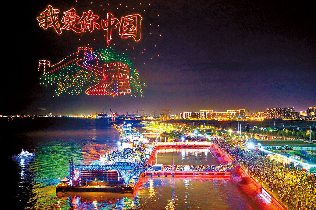 國慶主題無人機表演在江蘇南通舉行，吸引眾多遊客觀看。(新華社)
