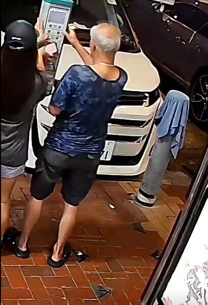 一名白髮男與一名戴鴨咀帽女子正在智能咪錶前同時操作,各不相讓。(FB/車cam L(香港群組))