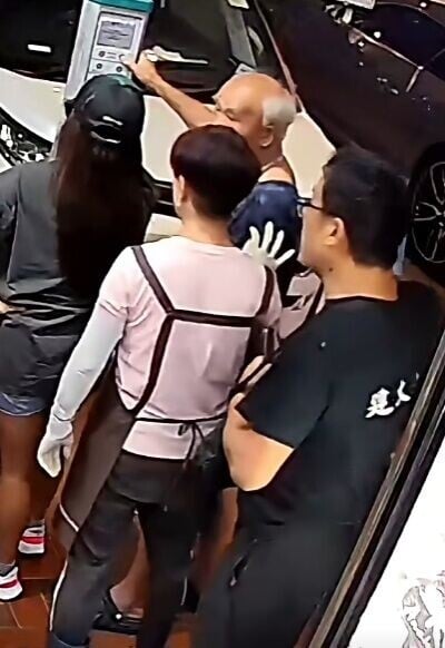 一名戴眼鏡男子和穿圍裙女子從後圍觀及嘮叨。(FB/車cam L(香港群組))