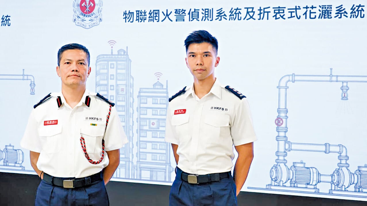 黎健武(左)和助理消防區長(樓宇改善策略及特別行動)曾昭樂介紹計劃擴展詳情。(周令知攝)