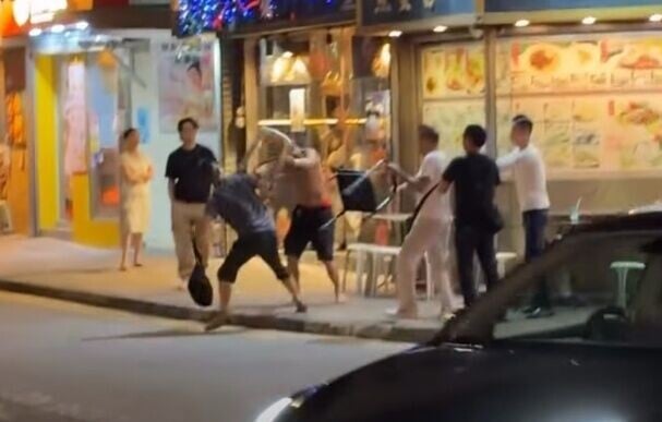 兩名男子分別持膠櫈及鐵櫈,夾擊一名赤膊赤腳的男子。(FB/車cam L(香港群組))