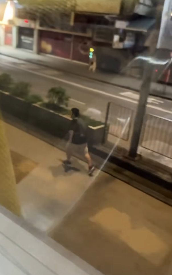 一名男子在晚上的彌敦道行車線上跑出馬路狂奔近百米,疑為會合友人一同拍攝巴士。(Facebook群組「車cam L(香港群組)」)