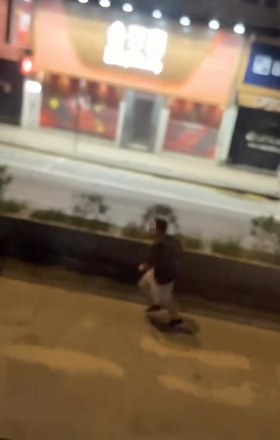 一名男子在晚上的彌敦道行車線上跑出馬路狂奔近百米,疑為會合友人一同拍攝巴士。(Facebook群組「車cam L(香港群組)」)