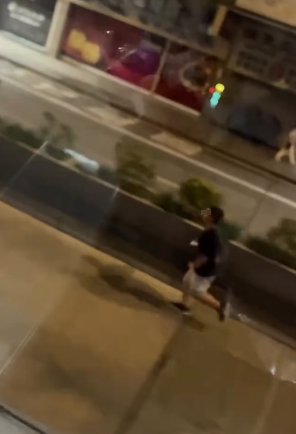 一名男子在晚上的彌敦道行車線上跑出馬路狂奔近百米,疑為會合友人一同拍攝巴士。(Facebook群組「車cam L(香港群組)」)