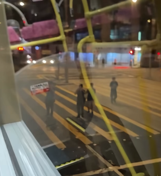 一名男子在晚上的彌敦道行車線上跑出馬路狂奔近百米,疑為會合友人一同拍攝巴士。(Facebook群組「車cam L(香港群組)」)
