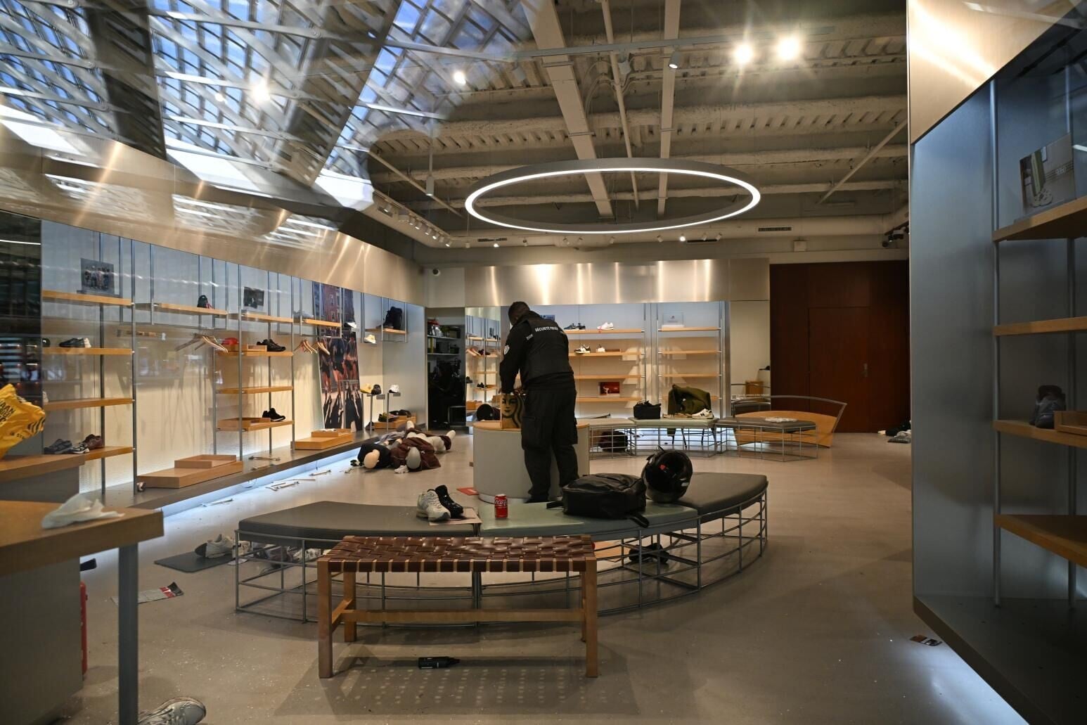 這次騷亂導致不少店家商品不翼而飛,損失慘重。圖為一名保安站在遭遇搶劫的店家內。(圖/美聯社)