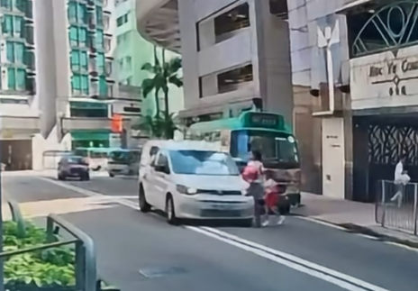 車Cam直擊︱羅便臣道一名45歲婦人與5歲女兒落小巴後橫過馬路時,一輛客貨車涉在雙白線爬頭越過小巴前行,結果將母女撞倒。(影片截圖)