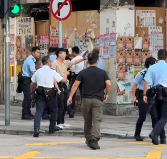 旺角登打士街與新填地街交界的十字路口,一名身穿深色上衣的男子在馬路中央被多名警員按倒在地,其後被帶到路旁調查。其間男子一度情緒激動,警員多次喝止要求他配合,不少途人駐足圍觀。(Threads)