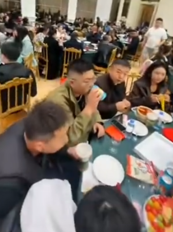 黑龍江省大慶市一對新人在酒店內舉行婚宴,當中數圍端上桌的竟然是多袋奶茶、炸雞等外賣食物(影片截圖)