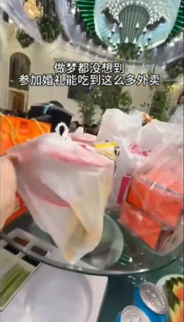 黑龍江省大慶市一對新人在酒店內舉行婚宴,當中數圍端上桌的竟然是多袋奶茶、炸雞等外賣食物(影片截圖)