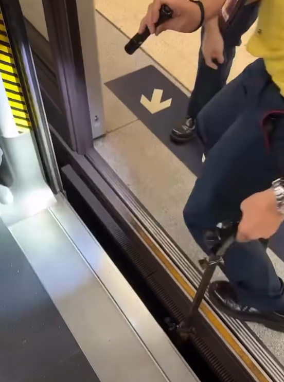 一名港鐵男職員趁列車短暫停站,用萬能夾伸入列車與月台之間的路軌罅隙,不足10秒便成功夾回乘客掉下的一隻蘋果AirPods耳機。(影片截圖)