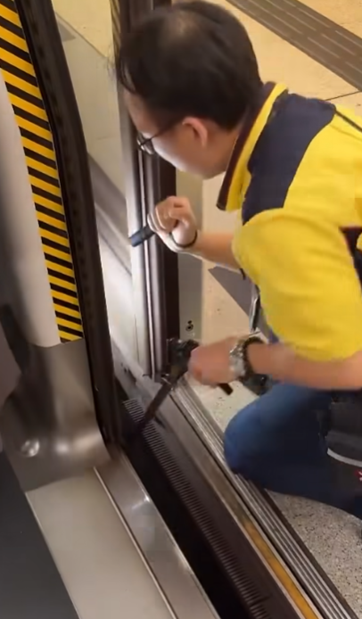 一名港鐵男職員趁列車短暫停站,用萬能夾伸入列車與月台之間的路軌罅隙,不足10秒便成功夾回乘客掉下的一隻蘋果AirPods耳機。(影片截圖)