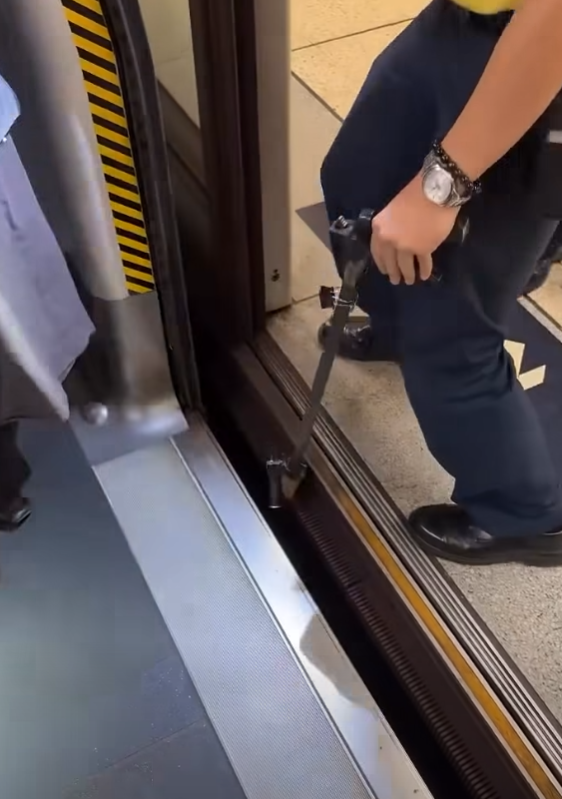 一名港鐵男職員趁列車短暫停站,用萬能夾伸入列車與月台之間的路軌罅隙,不足10秒便成功夾回乘客掉下的一隻蘋果AirPods耳機。(影片截圖)