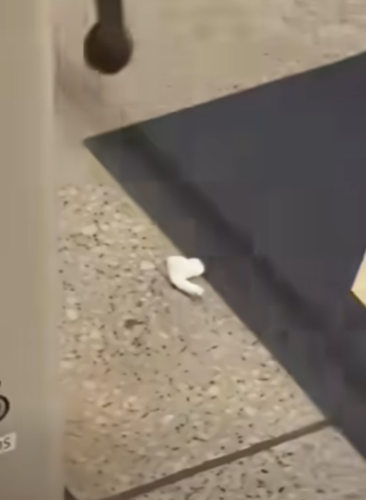 一名港鐵男職員趁列車短暫停站,用萬能夾伸入列車與月台之間的路軌罅隙,不足10秒便成功夾回乘客掉下的一隻蘋果AirPods耳機。(影片截圖)