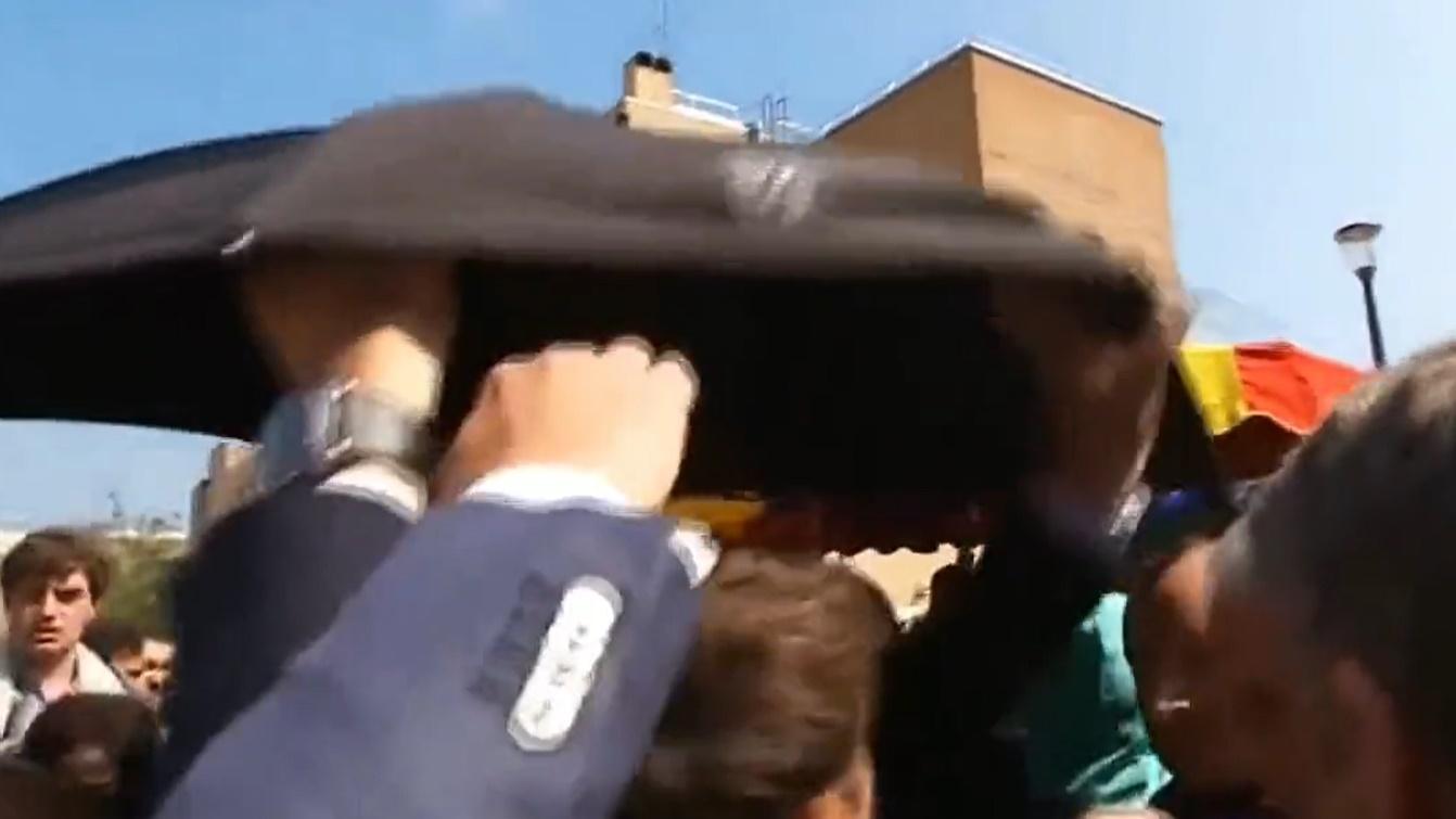 馬克龍險被民眾投擲的車厘茄擲中,在場保安一度開雨傘掩護。(Twitter)