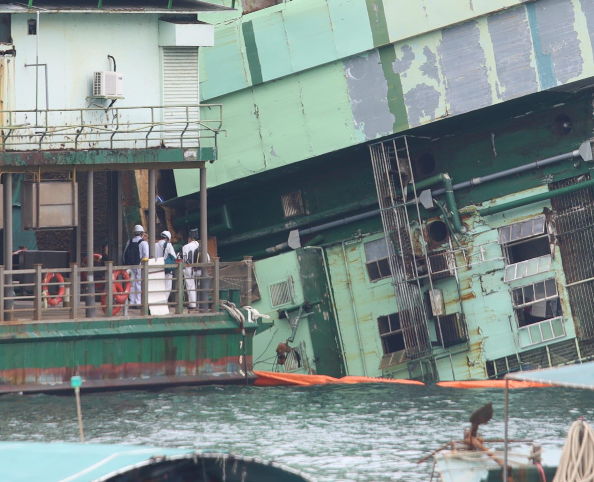 躉船船身嚴重傾側,近乎90度塌下,半邊船身浸在水中。(鍾式明攝)