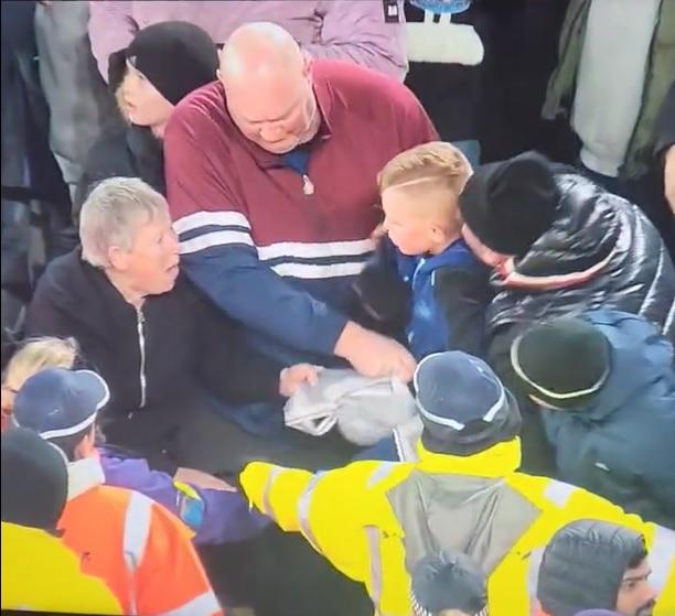 老婦在看台搶奪小孩的球衣。(影片截圖)