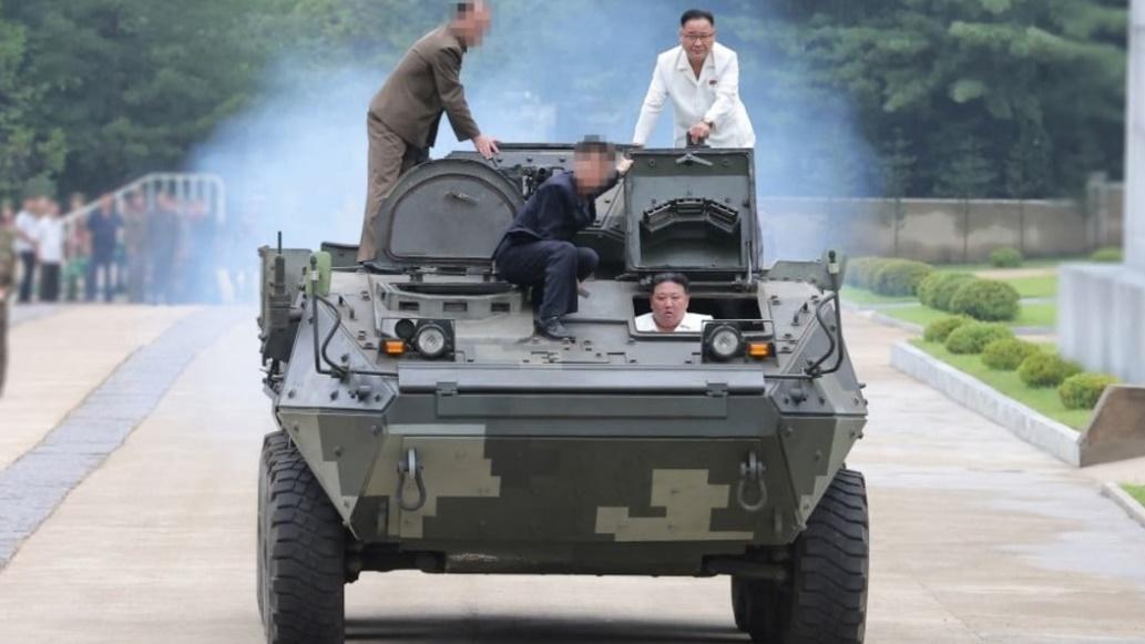 金正恩親自駕駛新開發的多用途戰鬥裝甲車。(朝中社)