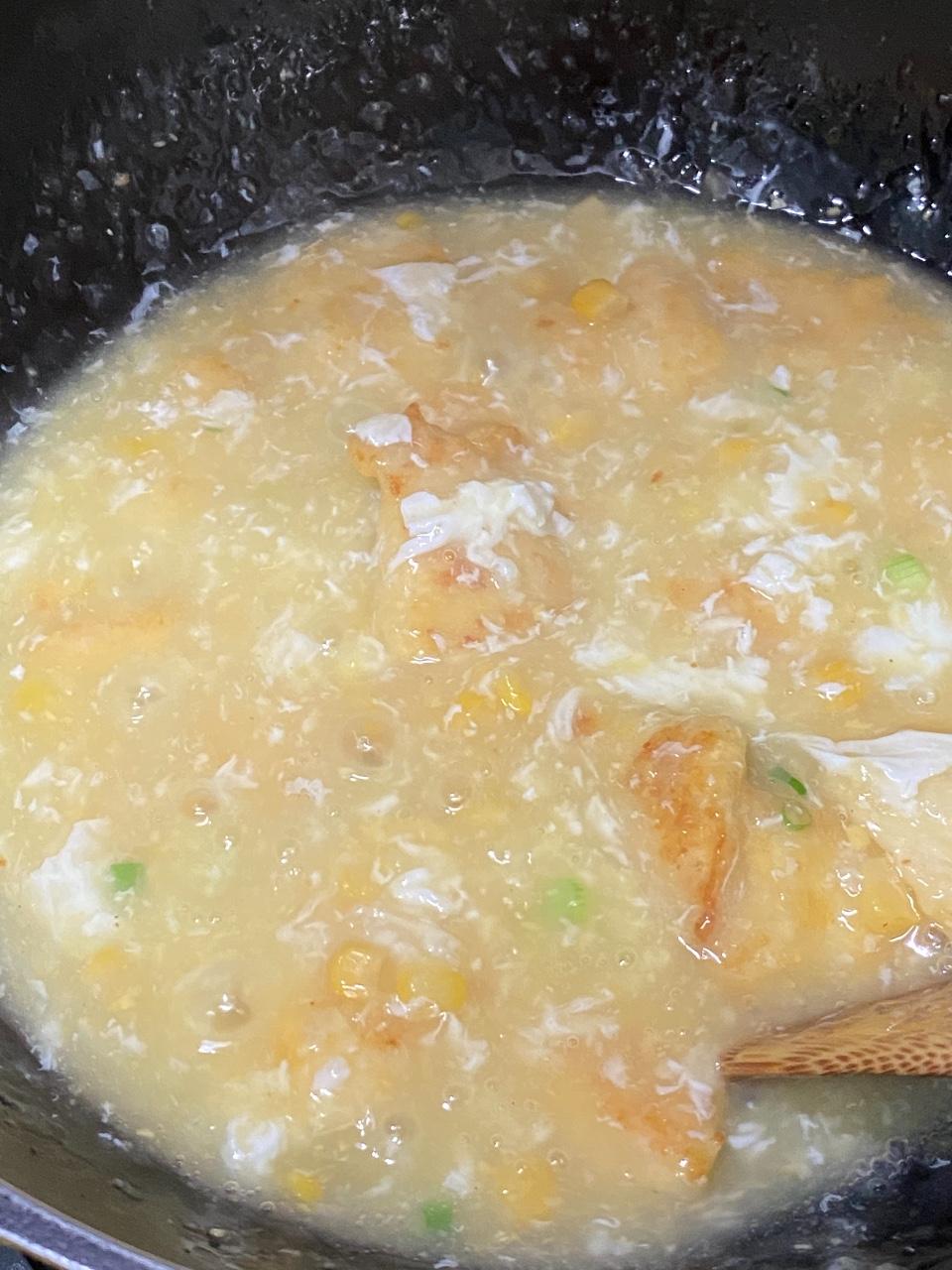 粟米斑塊食譜│步驟3 鑊中加油爆蒜茸,下清湯和粟米忌廉煮滾,加粟粉水煮至稠身。加蛋白製成蛋花,加魚塊回鑊,撒葱花。