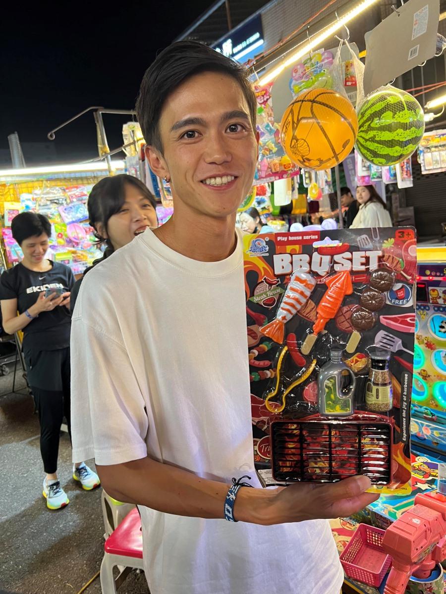 日本跑手大迫傑到訪台灣中壢夜市,玩了兩個遊戲獲得獎品(EKIDEN SPORTS 提供)