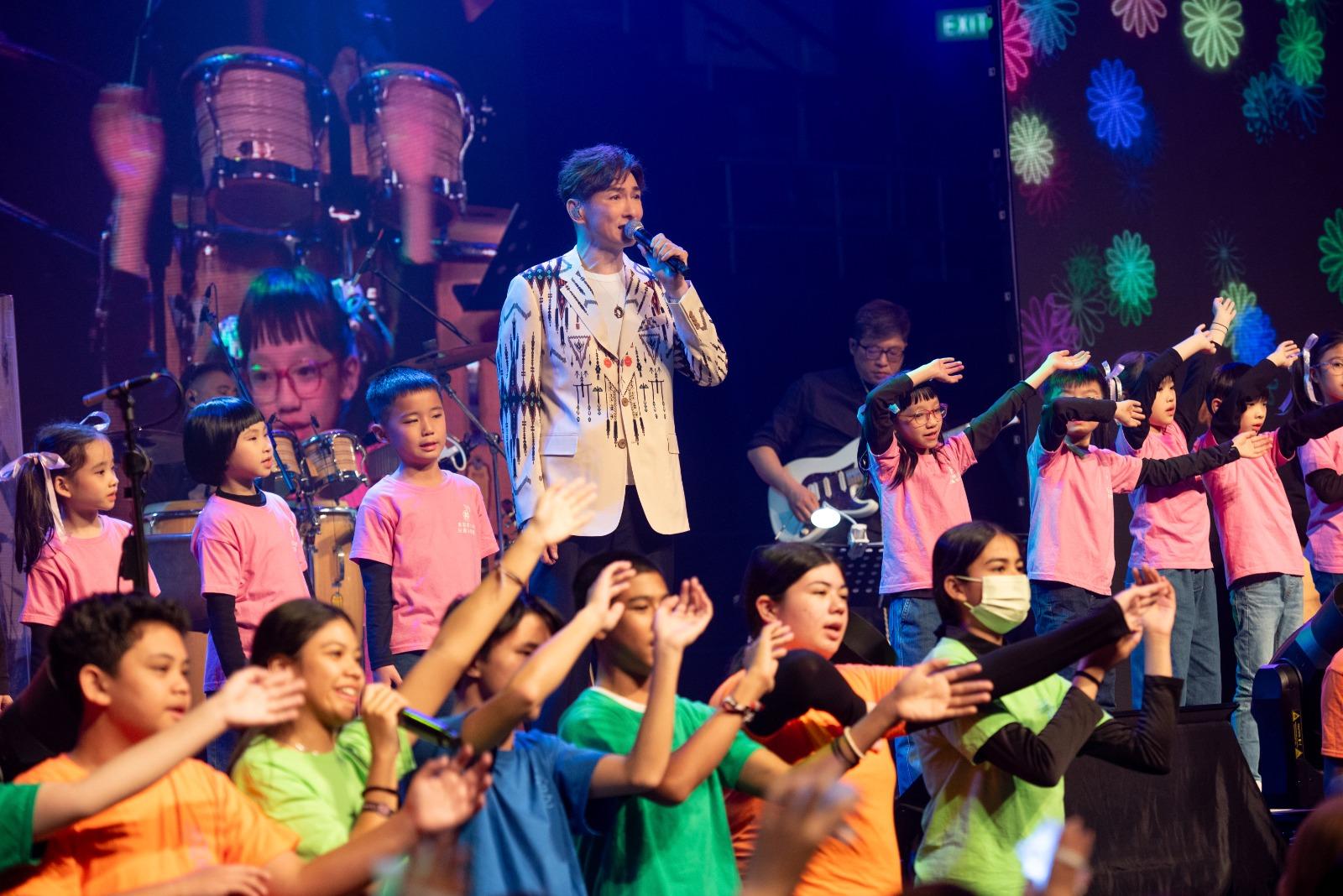 數十名小朋友和胡渭康合唱《Amani》。