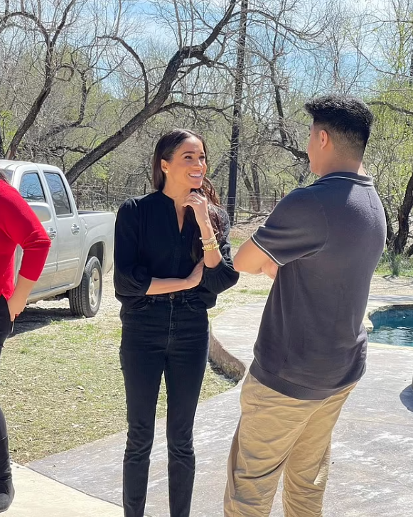 梅根與在槍擊案中犧牲的女教師姪兒聊天。(互聯網)